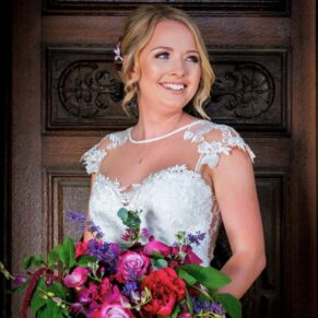 The bride photographed against the main wooden entrance doorway at Waddesdon Manor with some gorgeous soft lighting 
