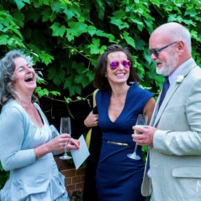 Candid moment of three giggling guests enjoying a catch up during the drinks reception at The Dairy 
