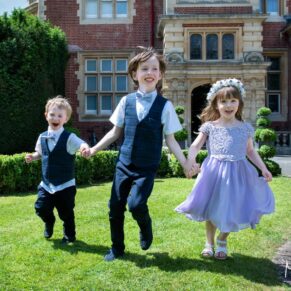 Wedding kids running around the grounds of the Pendley Manor Hotel with happy smiles