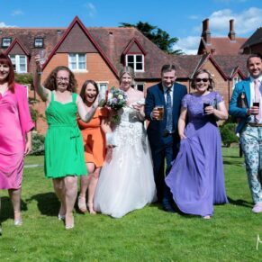 The newlyweds take a stroll in the gardens with their friends at their Pendley Manor Hotel wedding 