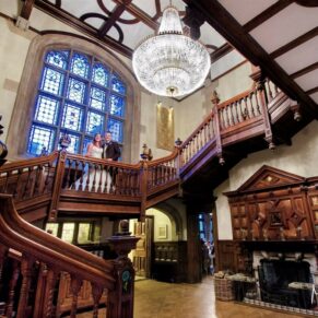 The newlyweds captured in a grand wide angle view of the staircase at their Pendley Manor Hotel wedding 