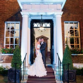 Sir Christopher Wren Hotel Wedding Photography - the newlyweds under the portico in the front doorway 