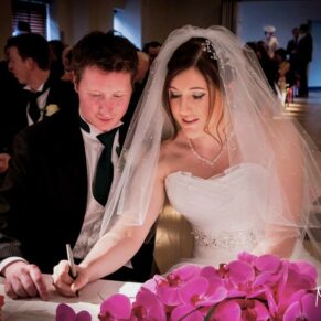 Stoke Place wedding photography - the newlyweds sign the register during the civil ceremony 