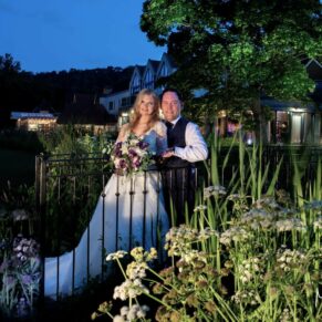 Swan at Streatley wedding - dusk floodlit shot of the newlyweds in the hotel gardens