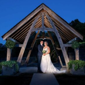 Dramatic floodlit night shot of the newlyweds in the grounds of the Tudor Barn in Burnham 