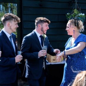 Reportage moment during the drinks reception of some guests enjoying the banter at the Tudor Barn