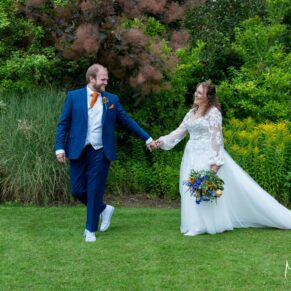 The bride and groom take a stroll in the gardens at their Olde Bell wedding reception in Hurley