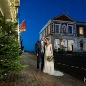 Photography of the newlyweds captured in front of the Christmassy Castle Hotel and Guildhall at nightfall at dusk on their wedding day in Windsor