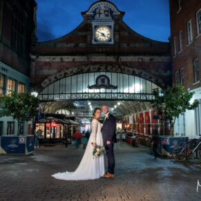 Photography of the newlyweds captured in front of the majestic Windsor Train Station after dark on their Castle Hotel wedding day