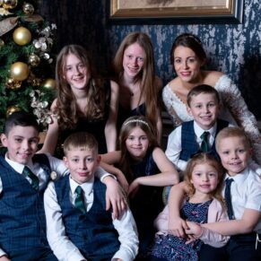 A group hug for this wonderful family photography pose next to the Christmas tree at this Castle Hotel wedding in Windsor 