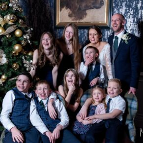 Very relaxed photography pose taken during the drinks reception next to the Christmas tree at this Castle Hotel wedding in Windsor 