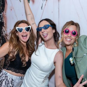 The bride with her girlfriends larking around inside the photo-booth with two of her girlfriends at her Dovecote Events wedding