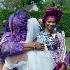 Time for hugs on the lush lawns during the wedding drinks reception at The Great House in Sonning