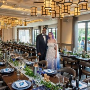 The smiling newlyweds pose for a picture in the The Great House in Sonning's stunning dining room prior to the wedding breakfast