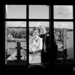 The bride and groom on the terrace looking back through the window at their Hotel Du Vin Henley wedding reception