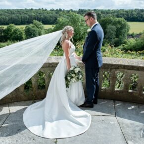 The breeze takes hold of the bride's veil for a fleeting moment on the outdoor terrace during her Latimer Estate wedding 