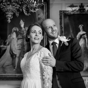 The newlyweds surrounded by grand portraits of Royalty inside the Guildhall