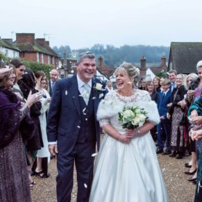 The jovial newlyweds make their way through the confetti aisle at their winter wedding reception