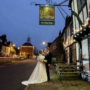 The newlyweds captured in Old Amersham High Street outside their Kings Chapel wedding reception venue at dusk 