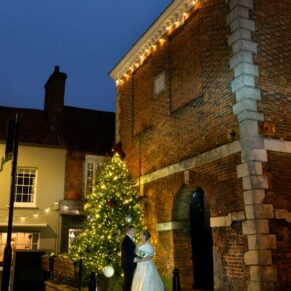 The Kings Chapel newlyweds captured beside Old Amersham High Street Market Square after dark on their Christmassy wedding day 