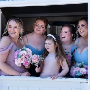 The smiling bridesmaids captured through the stable door just prior to the wedding ceremony at Meols Hall