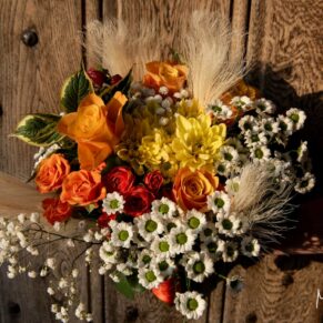 The bride's bouquet captured with a historic wooden door seen behind at The Manor House Hotel in Moreton-in-Marsh