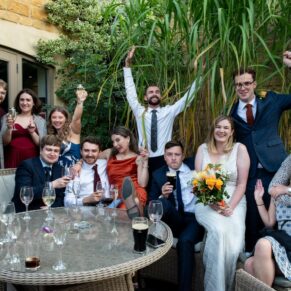 The couple larking around with their friends at their Manor House Hotel wedding in Moreton-in-Marsh