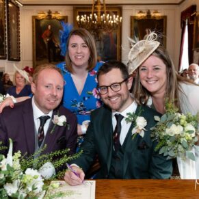 The happy newlyweds pose for the camera with their witnesses after the their marriage ceremony inside the Windsor Guildhall