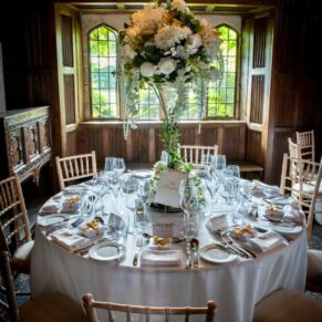 Photography from the balcony of this barn interior and floral arrangements prior to the wedding breakfast at this grand Buckinghamshire venue