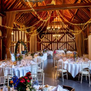 Photography of atmospheric barn venue interior all set for the wedding breakfast at this fabulous Buckinghamshire venue 