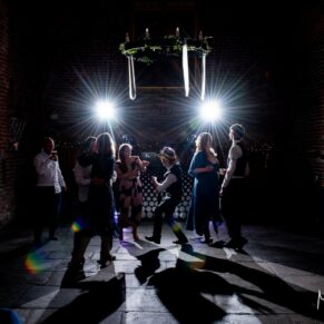 Dramatic dance floor photography of the wedding guests enjoying the vibe inside the historic tithe barn at this fabulous Buckinghamshire location 