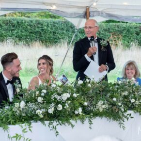 Buckinghamshire photography of the speeches in full flow inside a summer festival style rustic wedding marquee 