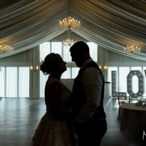 Buckinghamshire marquee wedding photography of the newlyweds in a dramatic silhouette pose, whilst capturing the interiors in the background