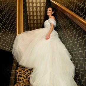 Relaxed photography of the bride sat on the funky stairs at her Crazy Bear Hotel wedding in Stadhampton